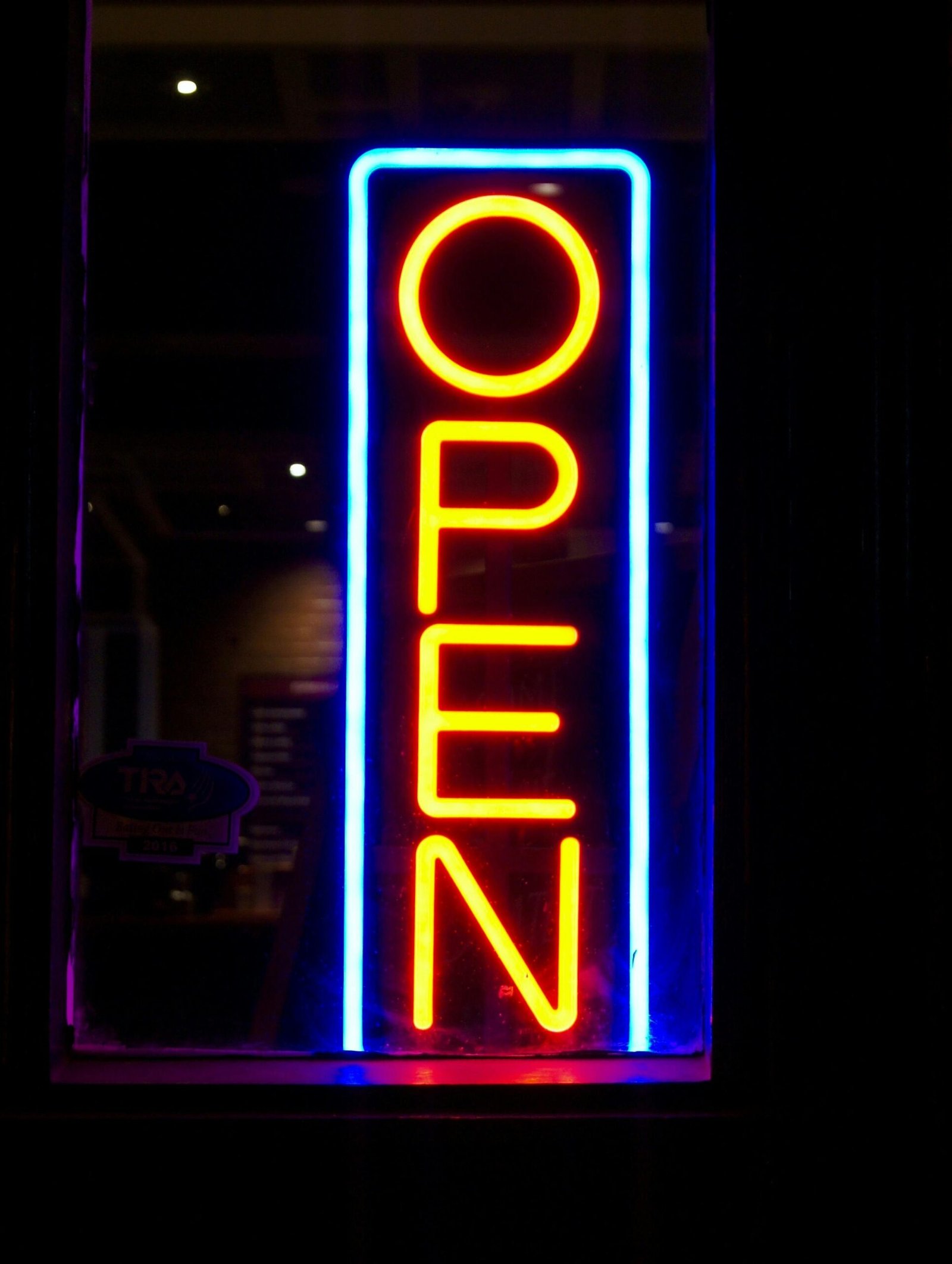 Illuminated neon sign displaying 'OPEN' with vibrant colors at night.